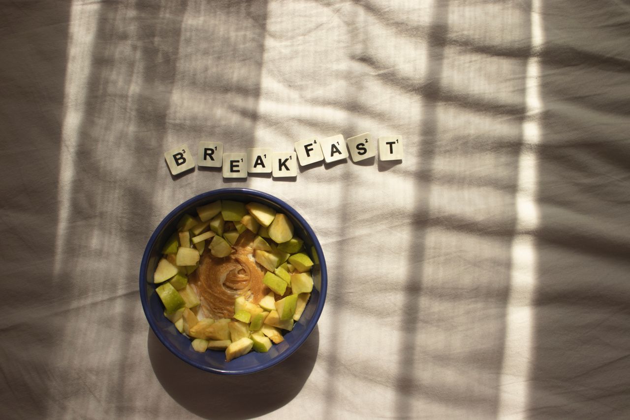 Home A nutritious breakfast bowl with peanut butter and apples in natural lighting.