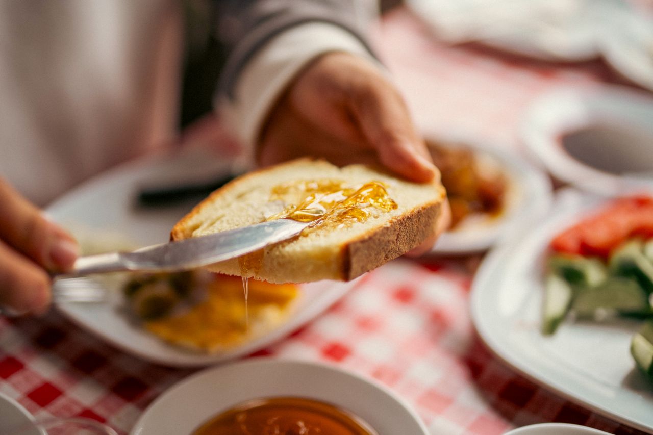 Home A delicious breakfast scene with honey spread on bread, enhancing the morning meal.